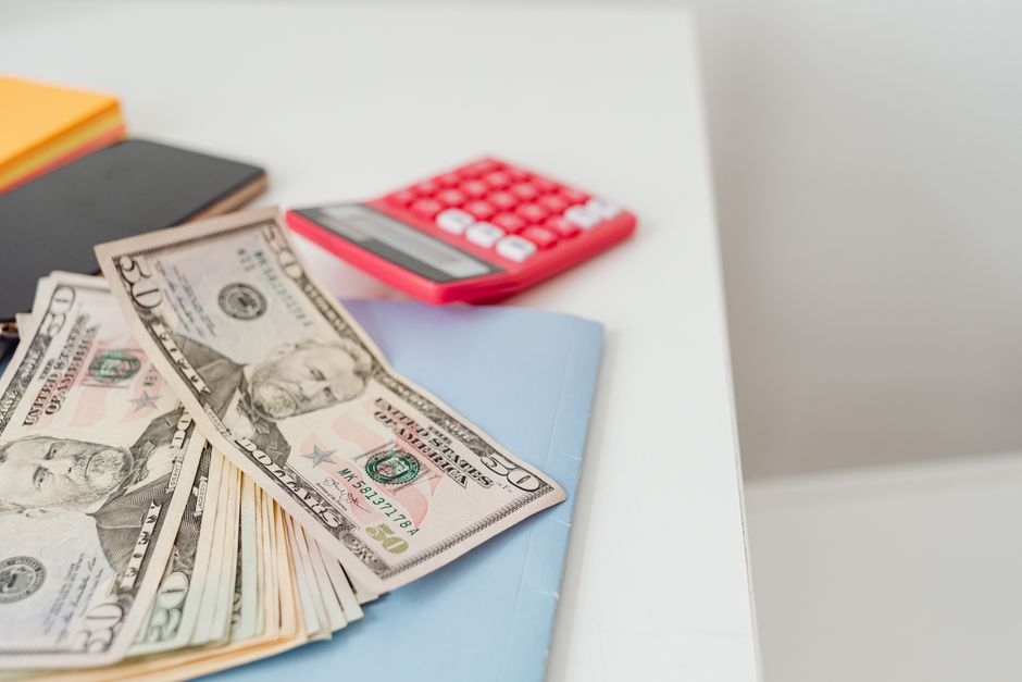 US dollar bills next to a calculator
